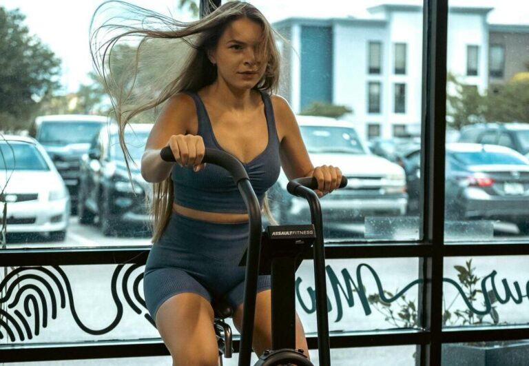 A Woman Using a Stationary Bicycle in Gym