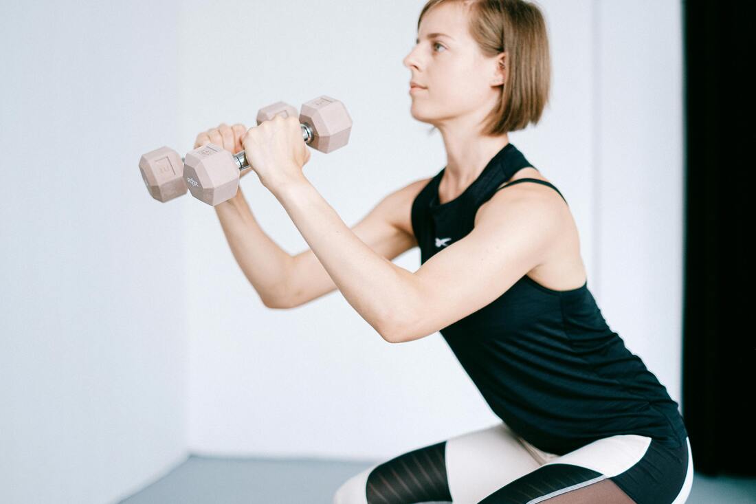 A beginner doing squats with dumbells