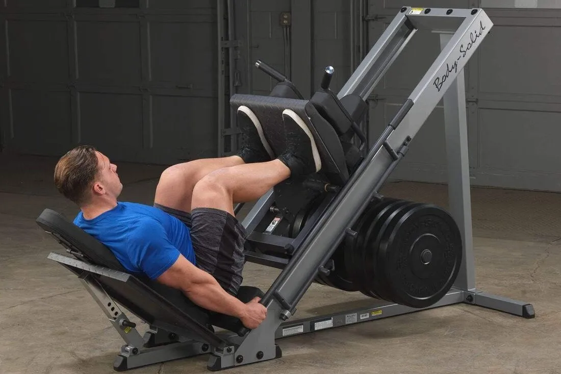 A compact leg press machine set up in a modern home gym