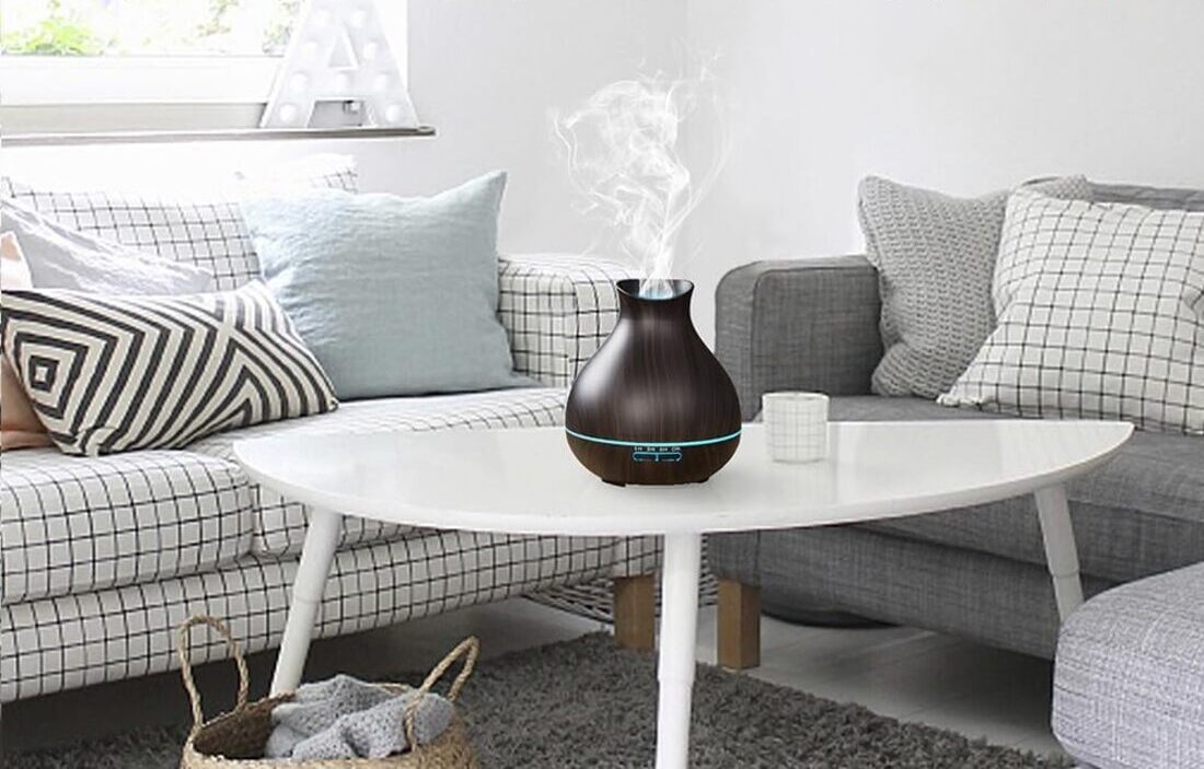 A modern ultrasonic essential oil diffuser with steam gently misting into the air