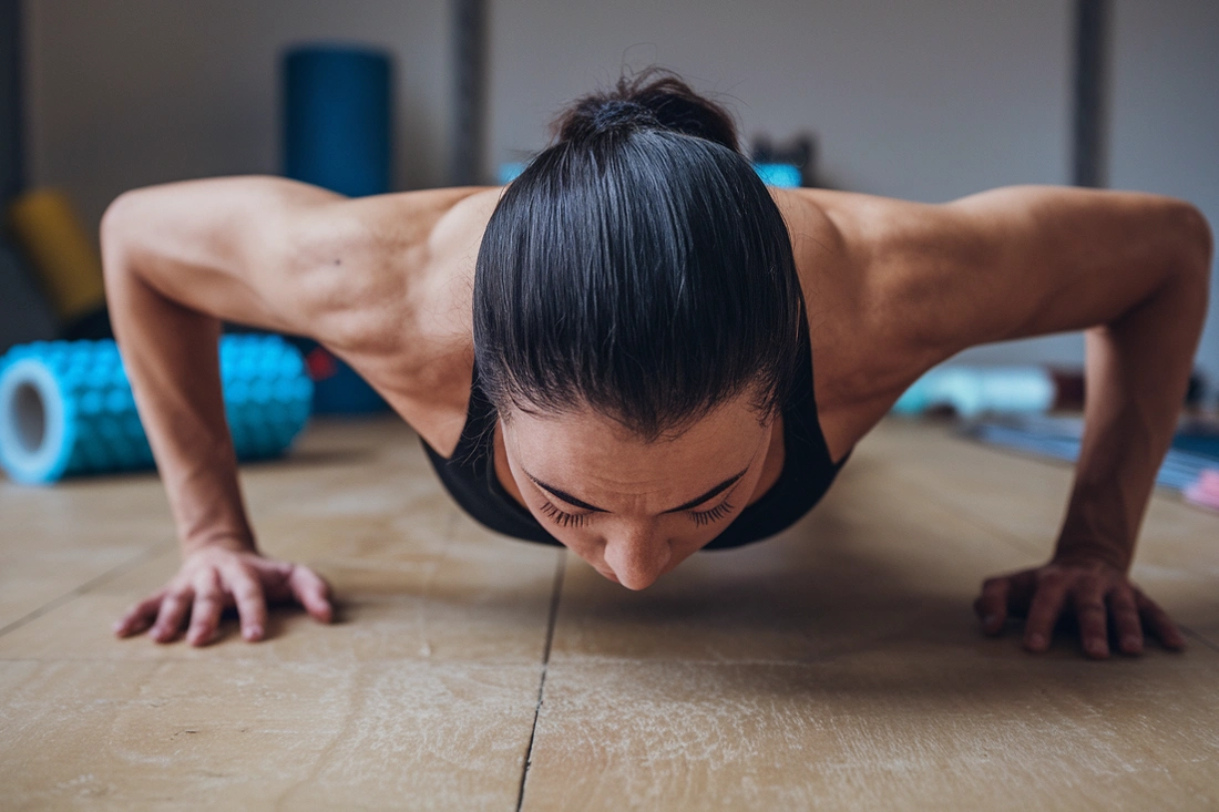 A person exercising or engaging in a physical activity, with a subtle hint of muscle recovery tool in the background