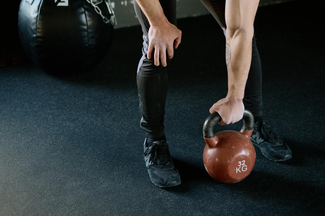 A person holding a kettlebell with a neutral grip highlighting proper wrist and arm positioning