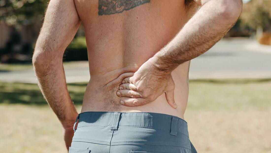 A person holding their lower back in pain.