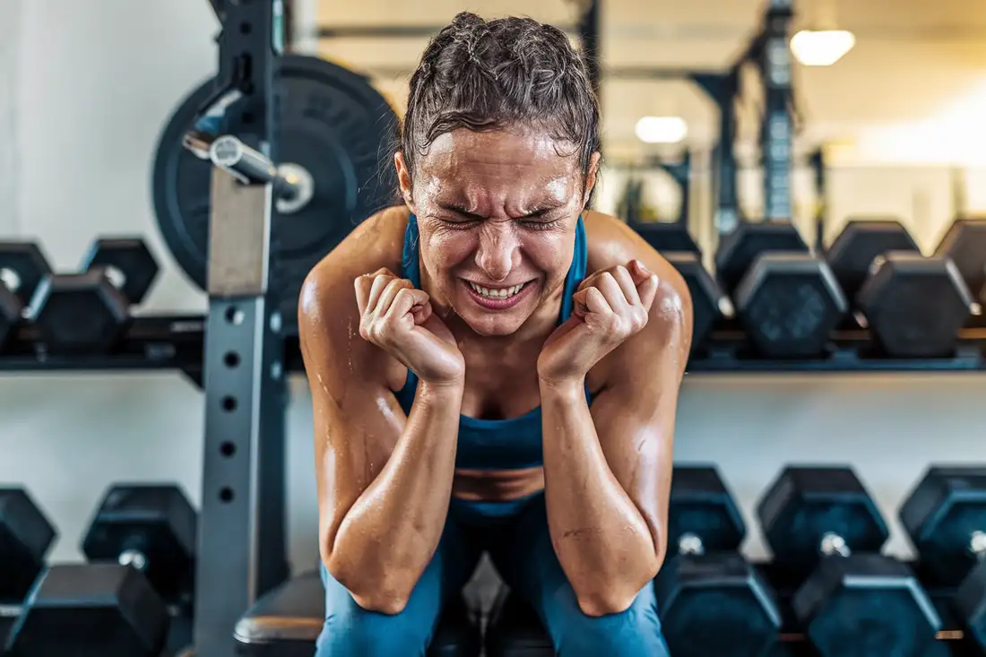 A person in a gym or fitness studio, with a mix of exhausted and relieved expression