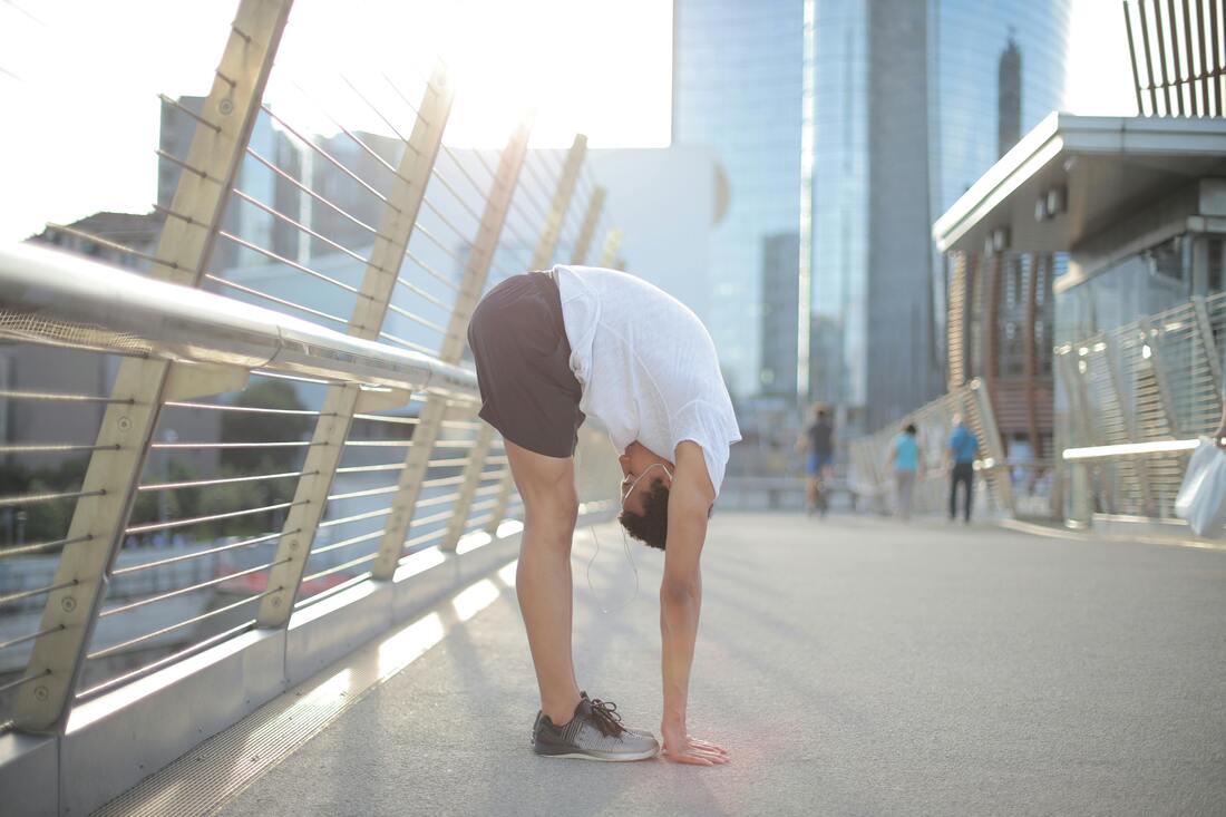 A person performing a squat with an excessive lower back arch, demonstrating a consequence of tight hip flexors