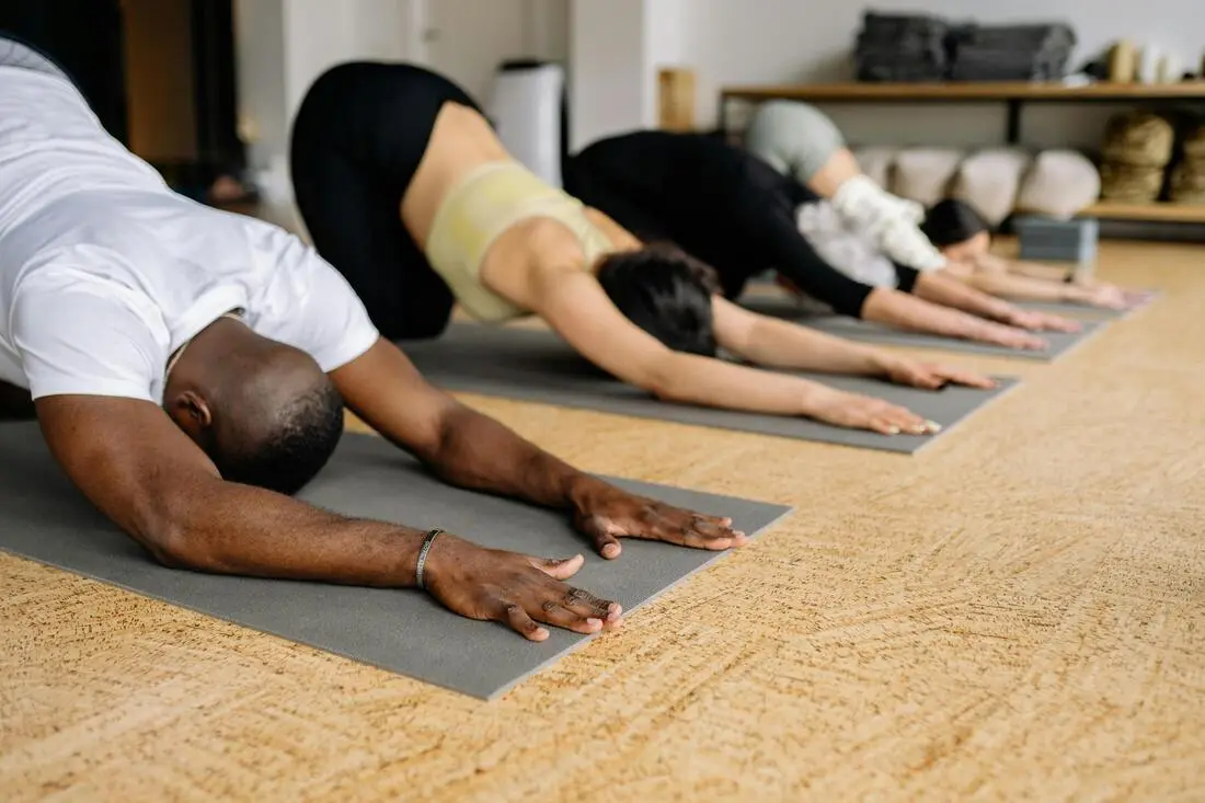 A person stretching in a child’s pose position on an exercise mat