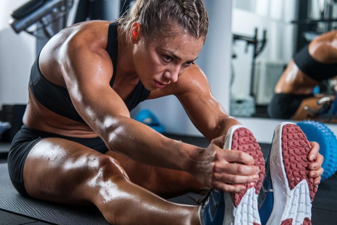 A person stretching, with a subtle hint of muscles or sweat