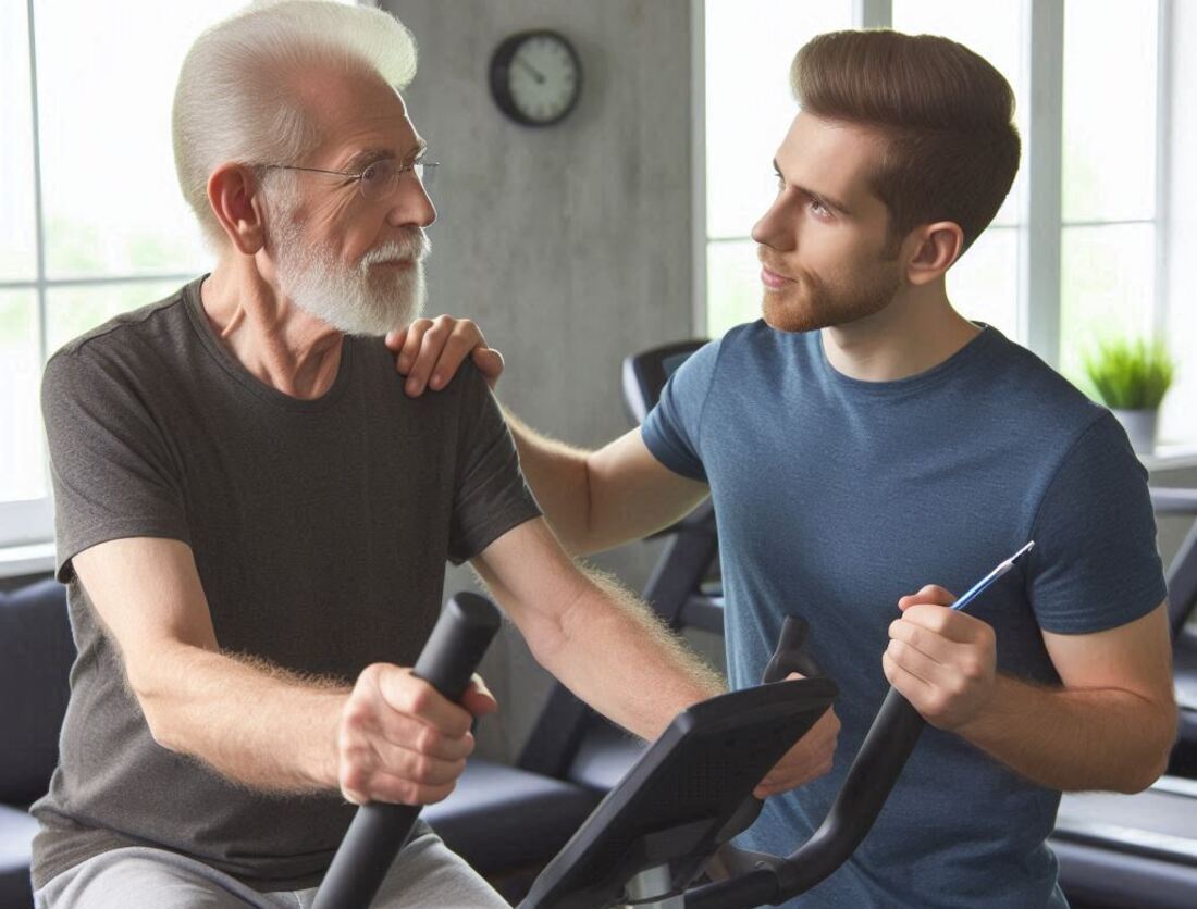 A senior man consulting with a personal trainer while using an upright exercise bike