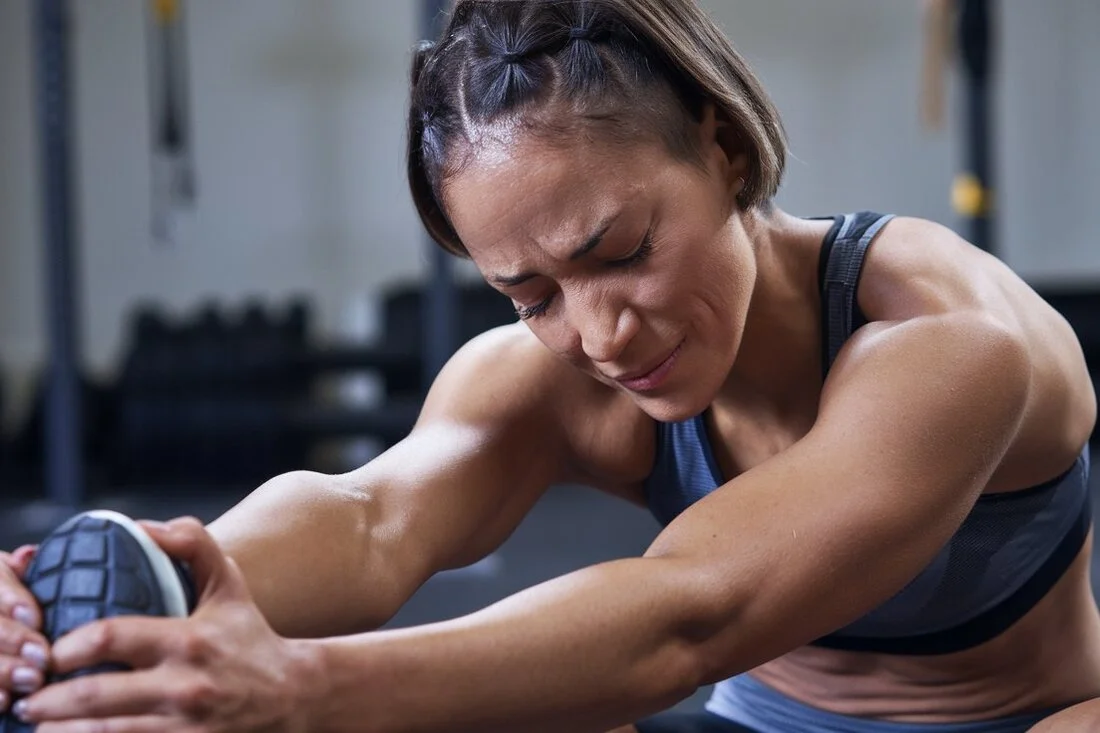 An athlete stretching after a workout, looking tired and sore