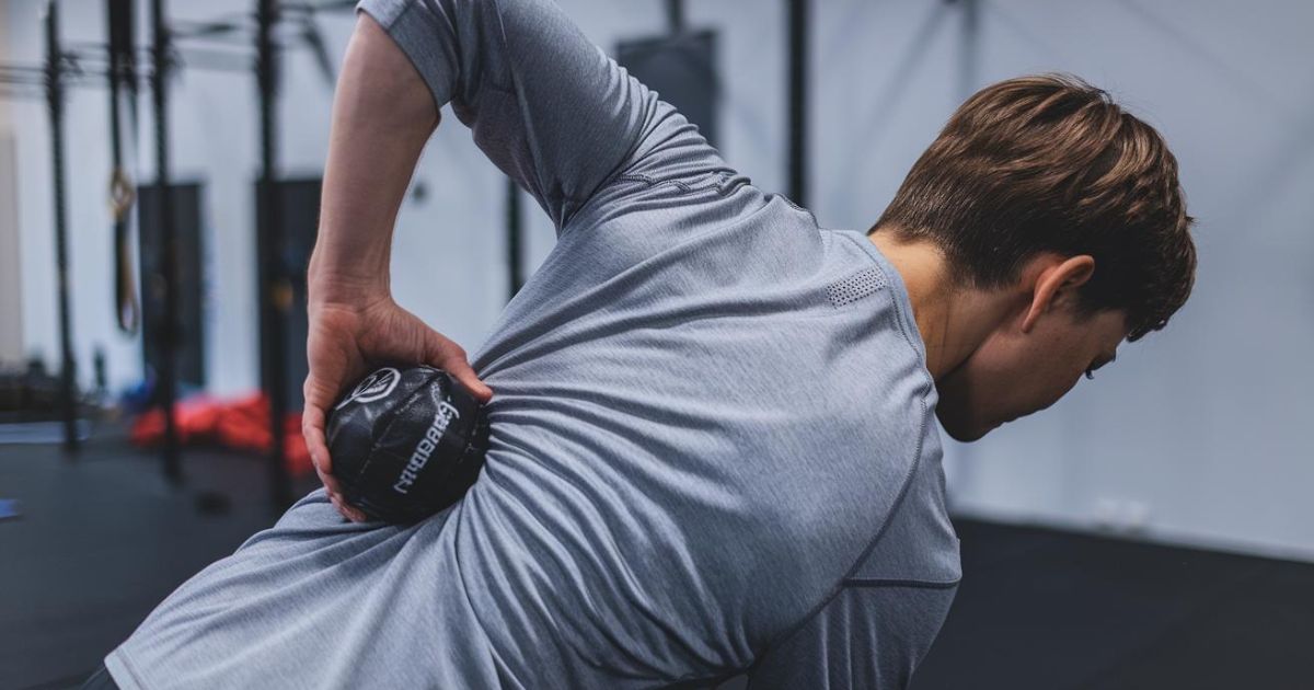 Athlete using a lacrosse ball on their back