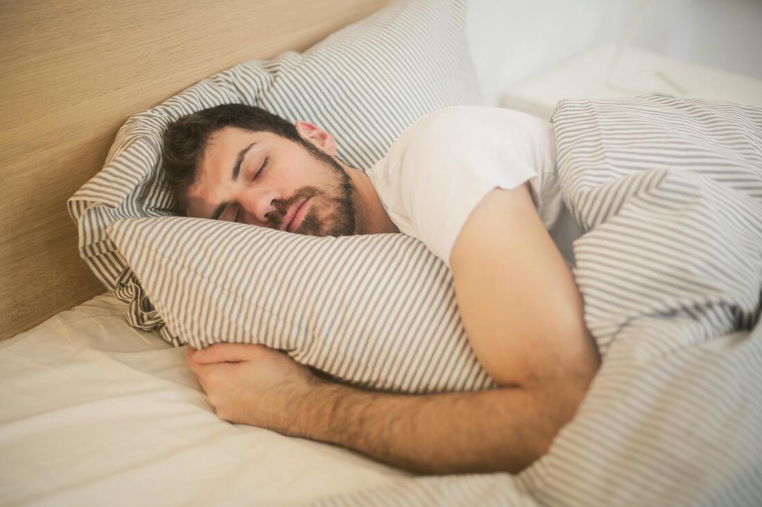 A person peacefully sleeping in a comfortable bed