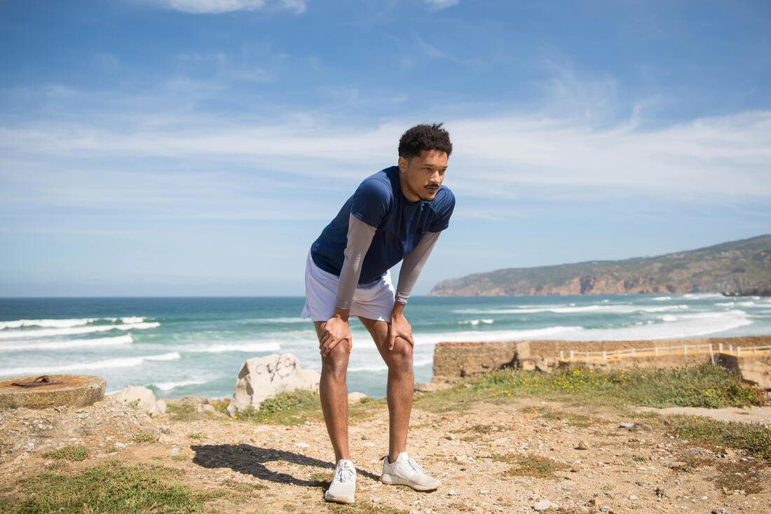 Person after running resting hands on knees appearing short of breath