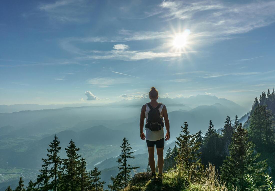 Person running or hiking outdoors with a clear blue sky in the background