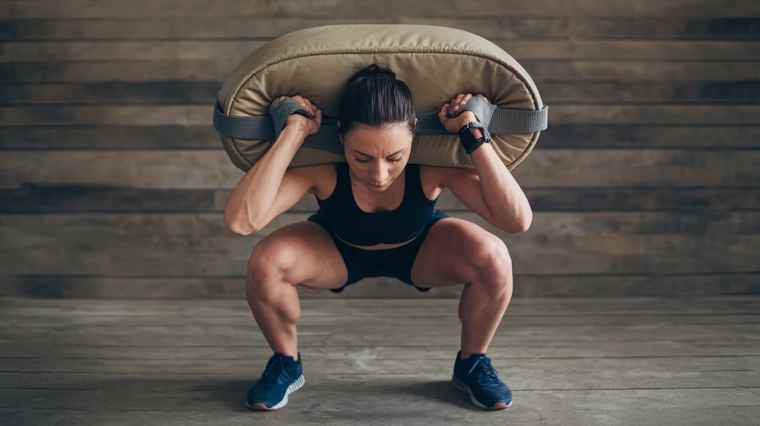 Person doing a sandbag squat, demonstrating how sandbag training builds leg and core strength for uphill hiking